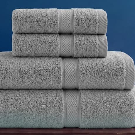 Bốn chiếc khăn Toweland màu ghi xếp chồng theo kích thước trên kệ gỗ.
